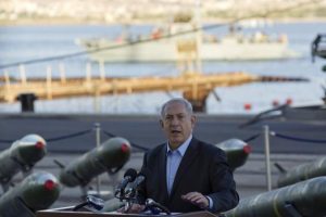 Israel's Prime Minister Netanyahu speaks to the media in front of a display of M302 rockets at a navy base in Eilat